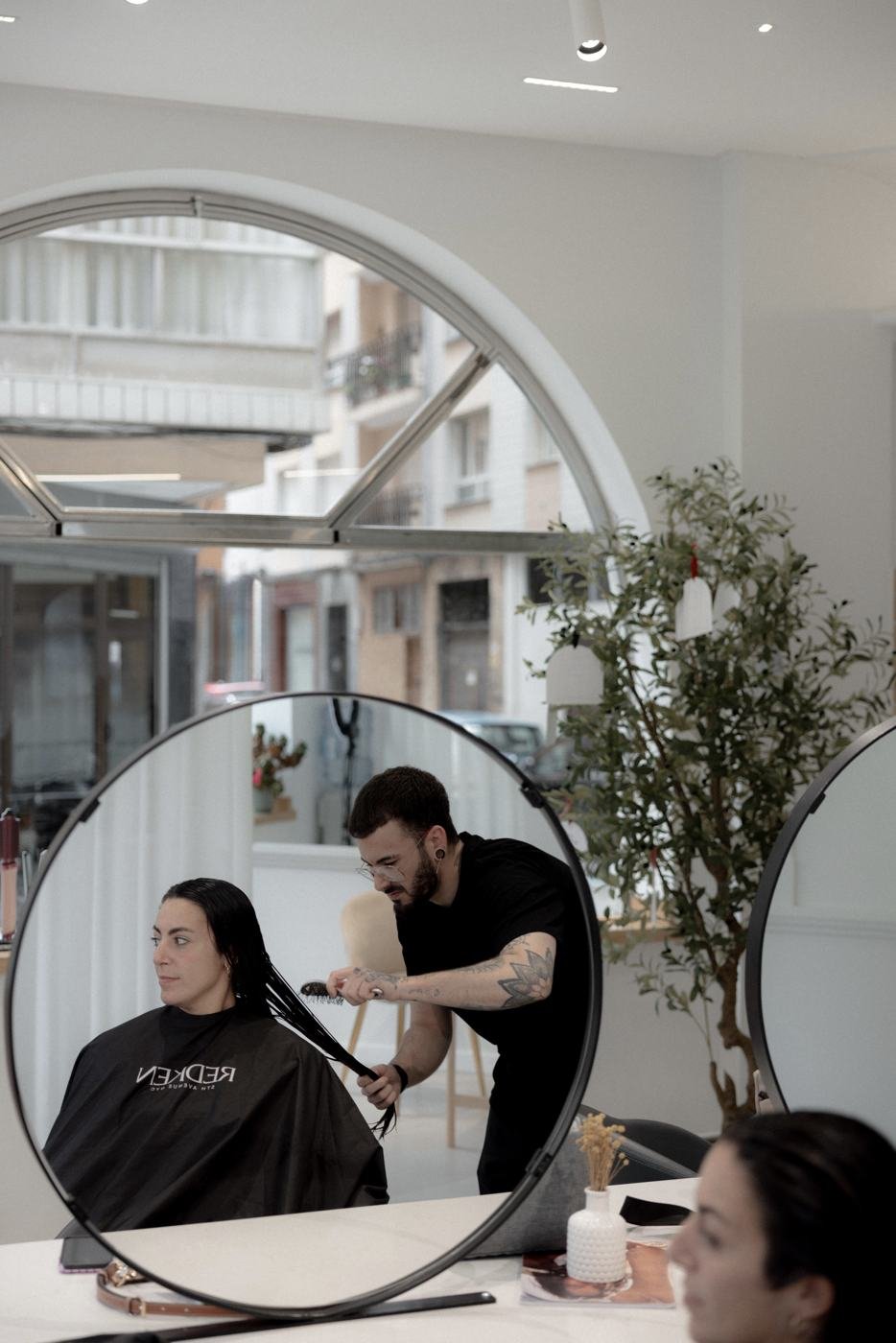 Corte de pelo de hombre frente al espejo redondo