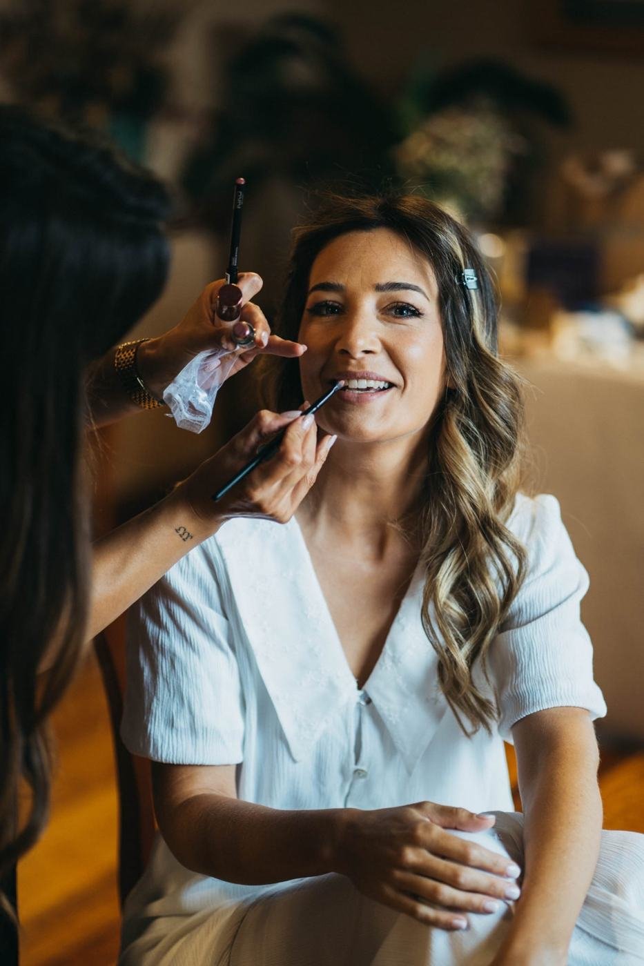 Novia durante el maquillaje y peinado de boda